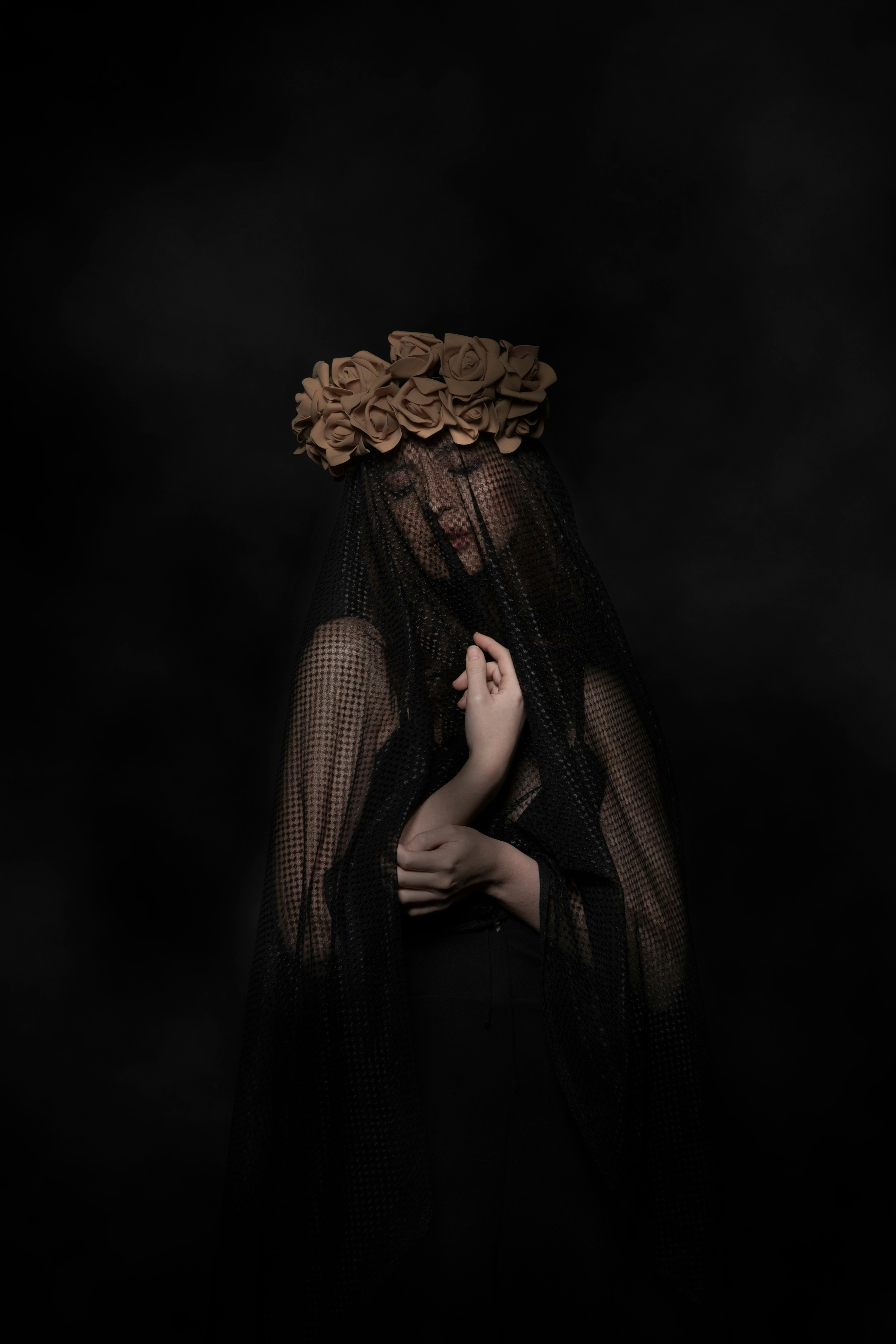 Woman looking to the side covered in a dark veil 